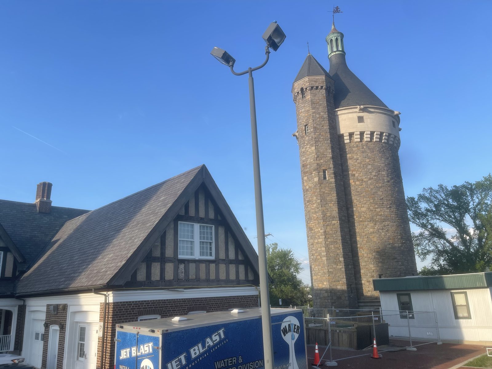 Historic stone water tower beside a utility building
