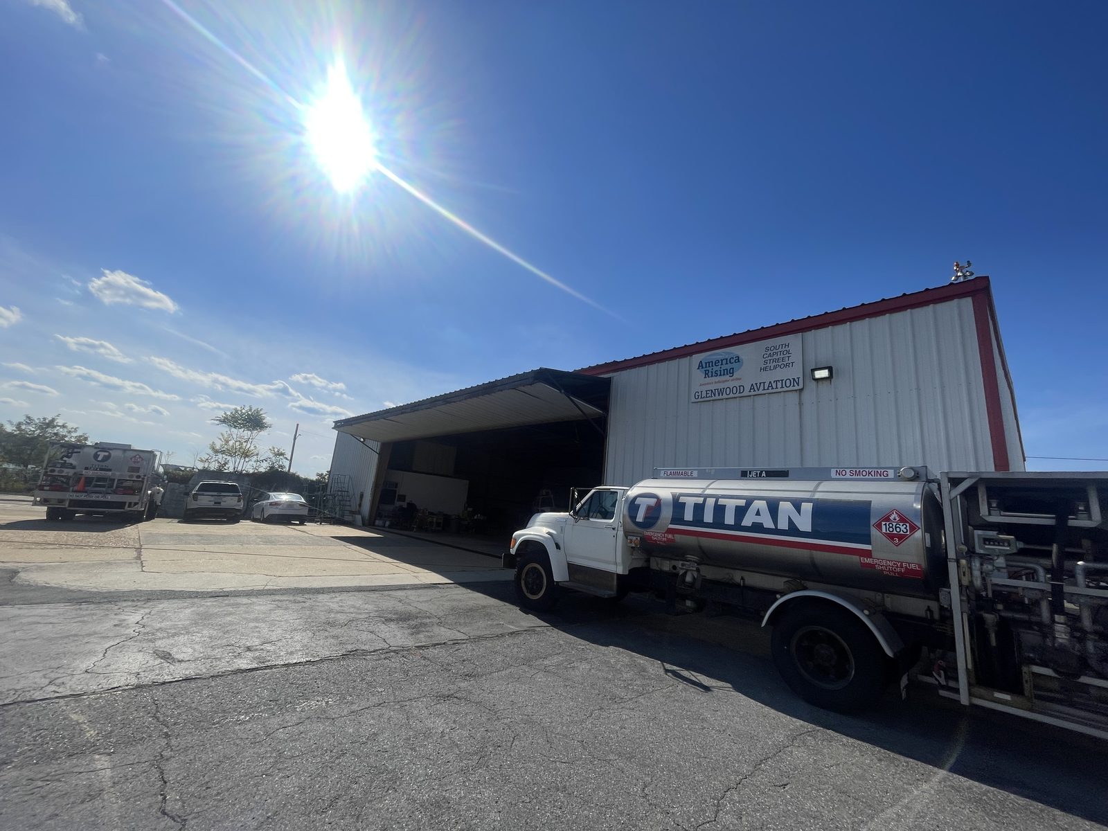Aviation fuel truck parked at an open aircraft hangar