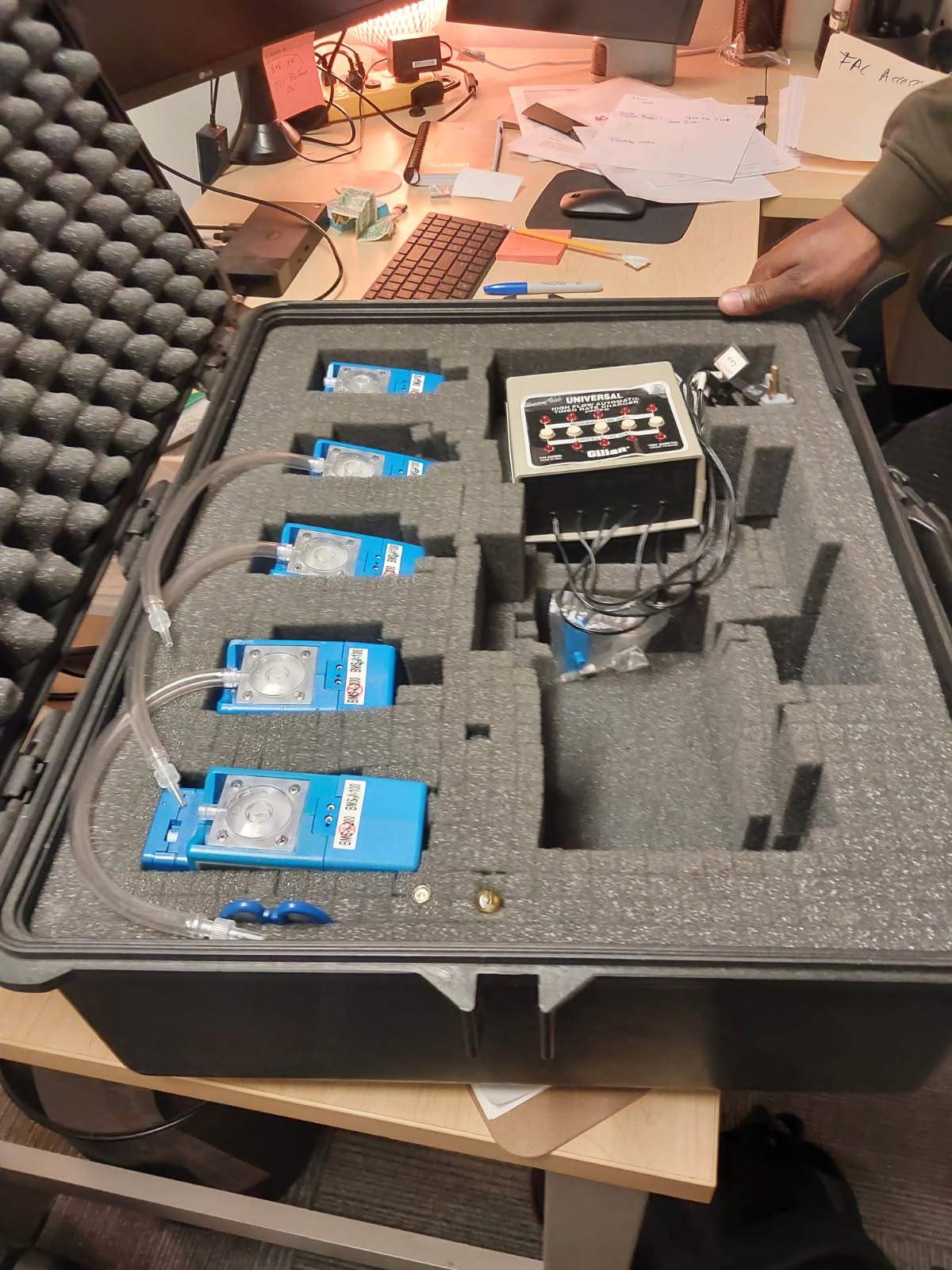 Portable air sampling pumps and charger organized in a protective case
