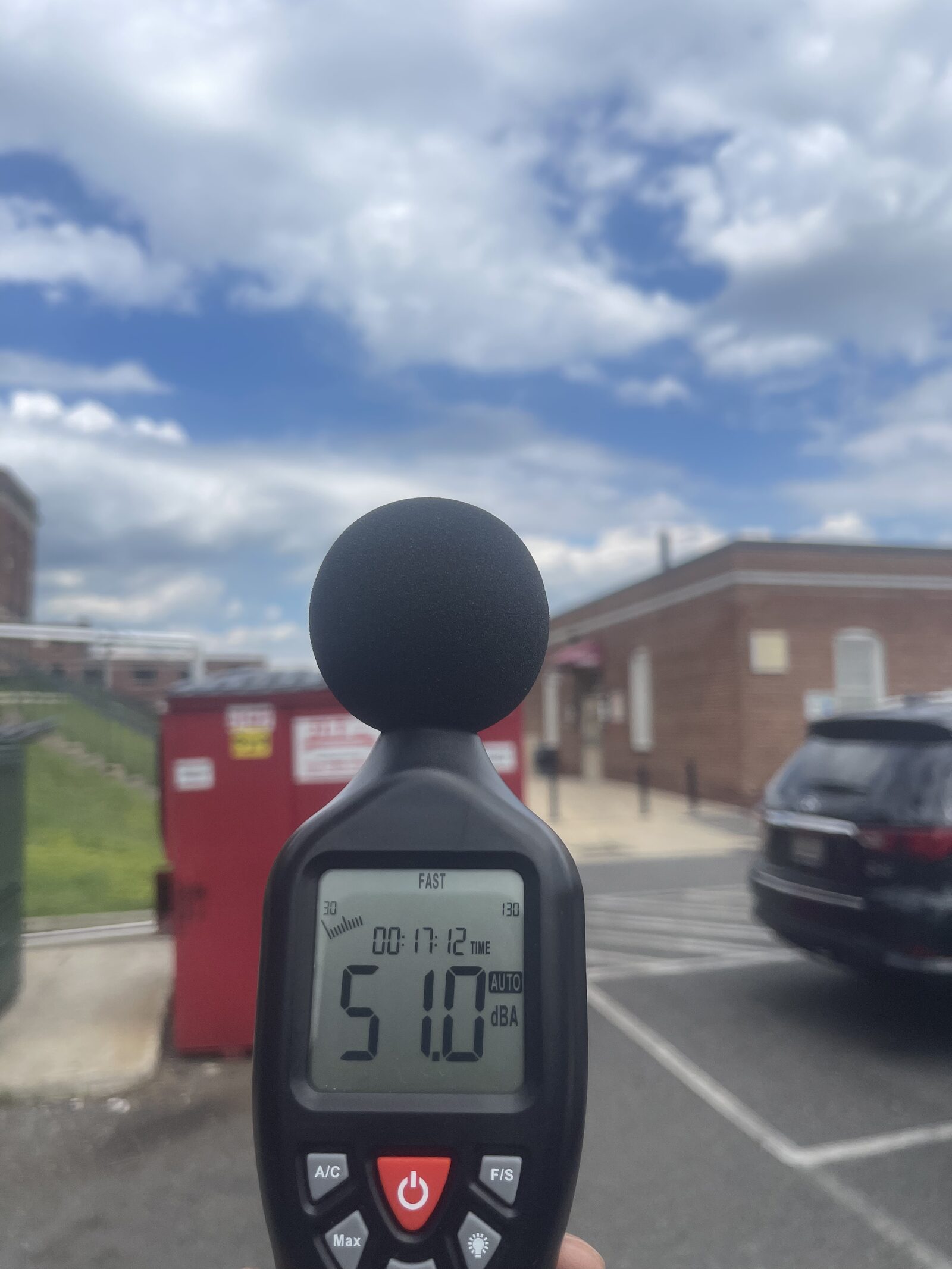 Sound level meter reading 51.0 dBA outside a brick building